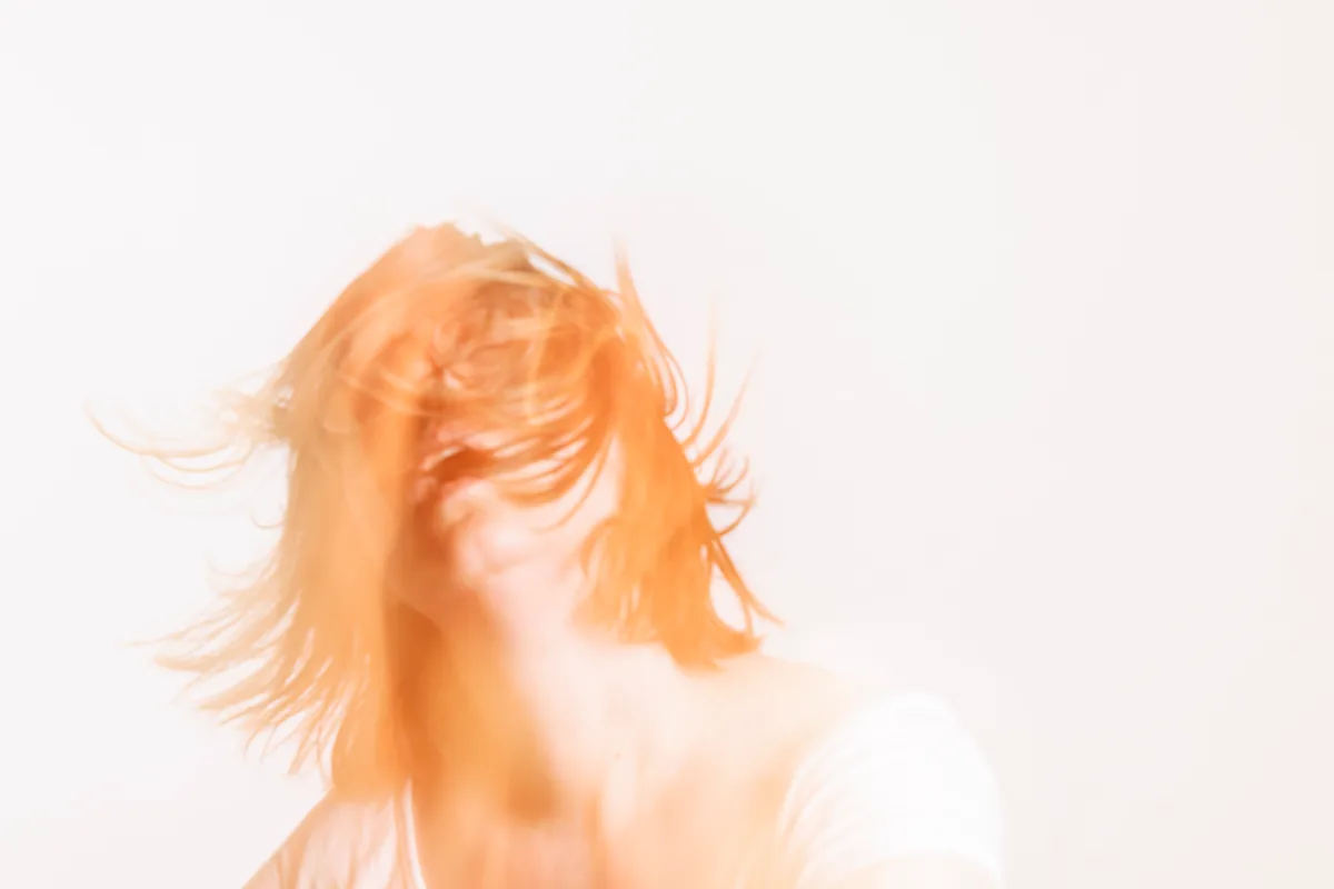 «Der Aufschrei» aus Sandra Stamms Fotoserie «Latent». Eine Frau, ihr Gesicht ist verdeckt durch ihr Haar. Sie sieht aus, als würde sie aufschreien.